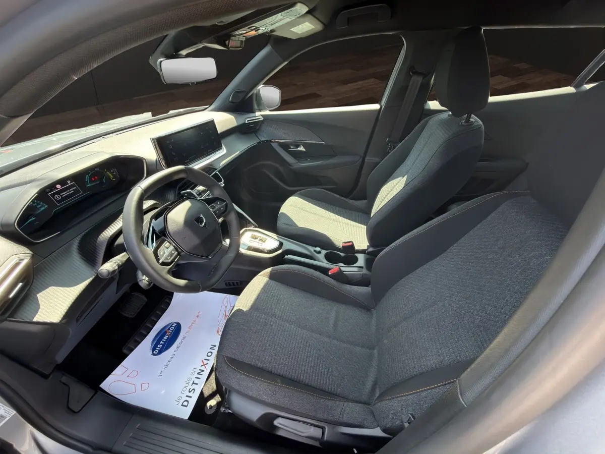 Vue intérieure côté conducteur du Peugeot 2008 Hybrid 145 e-DCS6 STYLE 2025 avec volant cuir multifonctions et écran tactile.