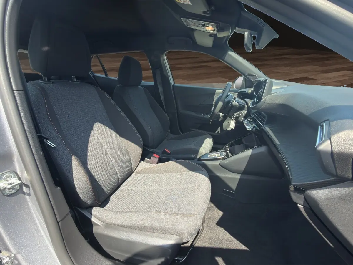 Vue intérieure côté conducteur du Peugeot 2008 Hybrid 145 e-DCS6 STYLE gris clair, avec sièges tissu et tableau de bord moderne.