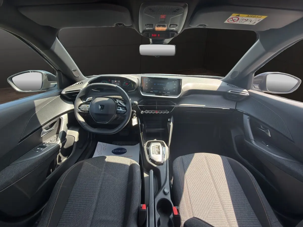 Vue intérieure avant du Peugeot 2008 Hybrid 145 e-DCS6 Style 2025, volant cuir multifonctions et écran tactile central.