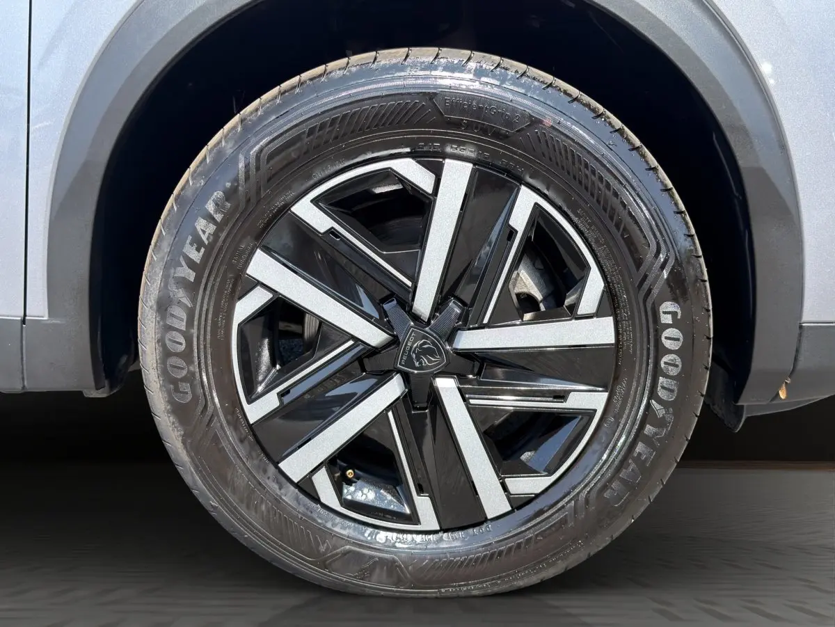 Gros plan sur la roue avant droite gris clair du Peugeot 2008 Hybrid 145 e-DCS6 STYLE avec jante noire et argent.