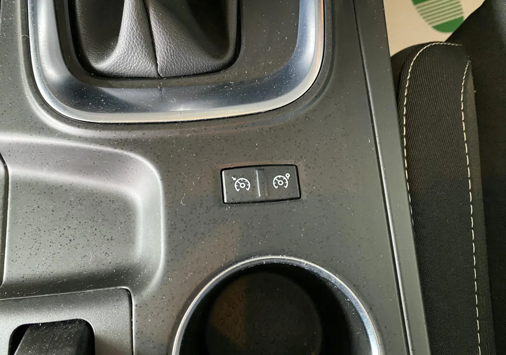 Gros plan sur les commandes de régulateur de vitesse au centre console d'une Renault Mégane IV Business gris, intérieur tissu noir.