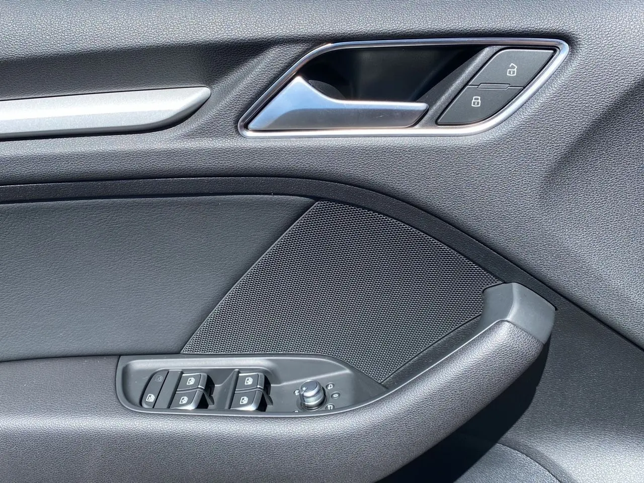 Détail de la porte côté gauche de l'Audi A3 Sportback noire 2020, avec commandes de vitres et verrouillage.