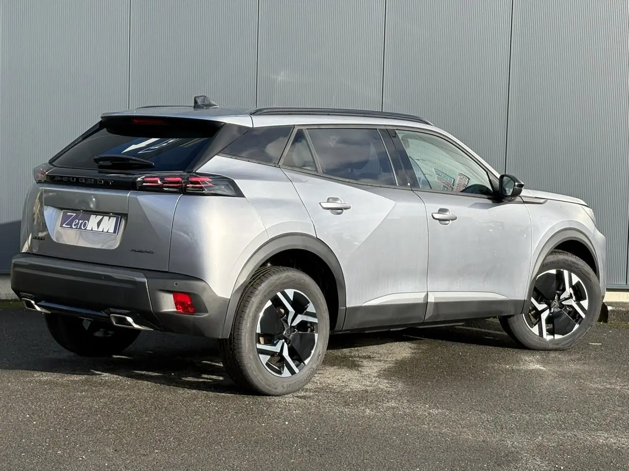 Peugeot 2008 Hybrid 145 e-DSC6 Allure gris Artense vue 3/4 arrière droit avec jantes bi-ton et feux LED griffés.