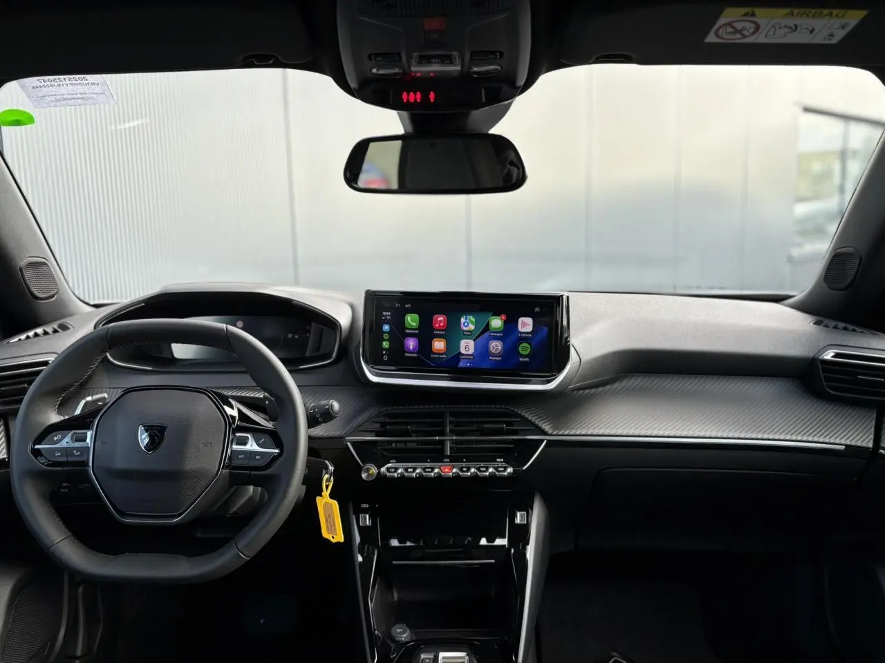 Vue frontale de l’habitacle noir du Peugeot 2008 Hybrid 145 Allure avec écran tactile central et volant compact cuir.