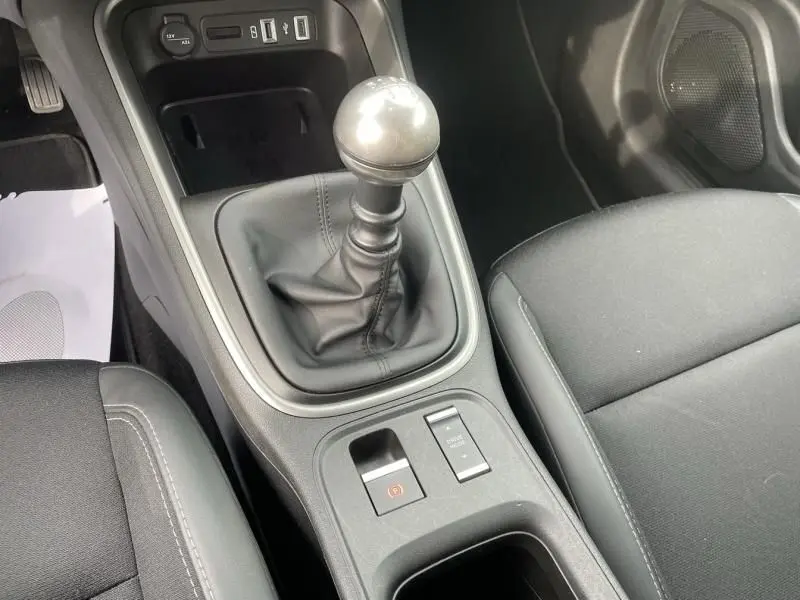 Gros plan sur la console centrale avec levier de vitesse manuel et sièges noirs du Jeep Avenger gris métal 2025.