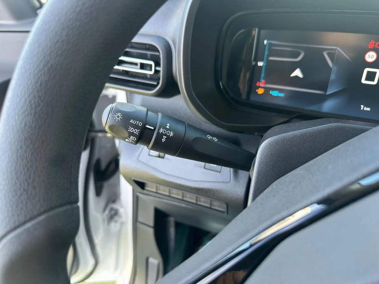 Vue intérieure de la zone de chargement arrière du Citroën Berlingo blanc Icy avec plancher bois antidérapant et parois noires.