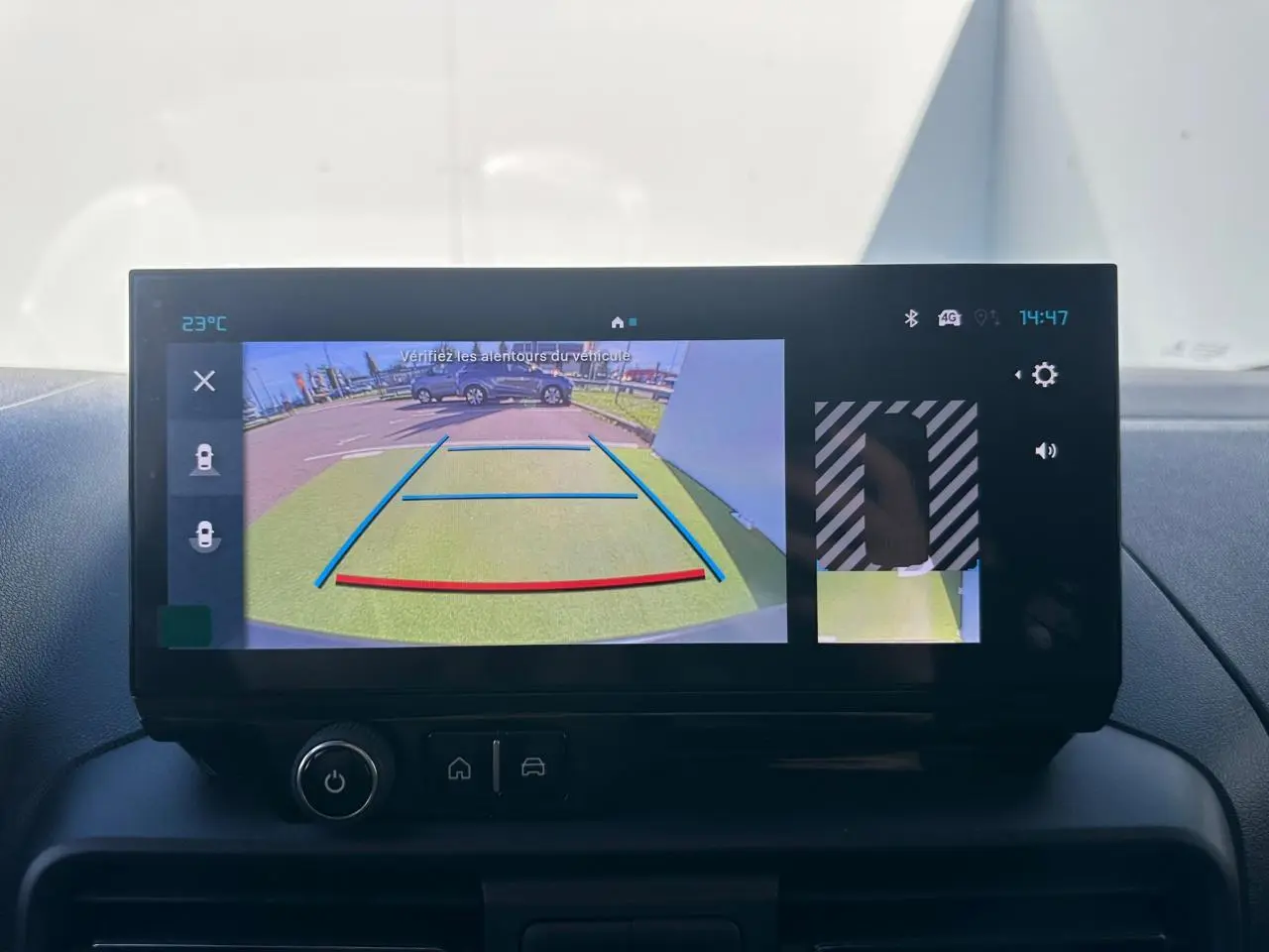 Rétroviseur droit noir brillant du Citroën Berlingo blanc Icy, vue rapprochée sur fond de carrosserie blanche.