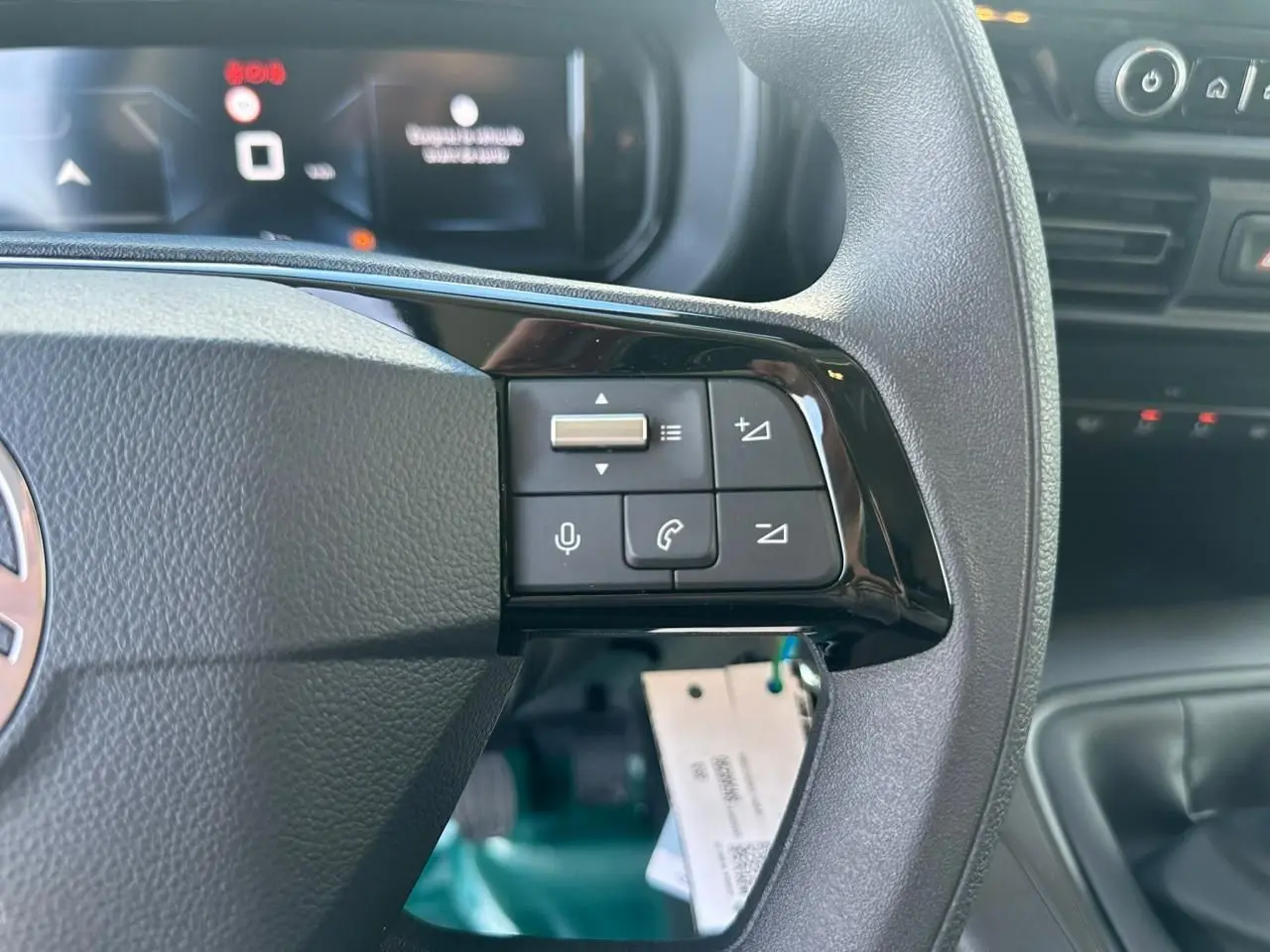 Gros plan sur le volant multifonctions du Citroën Berlingo blanc Icy, avec commandes audio et téléphone visibles.