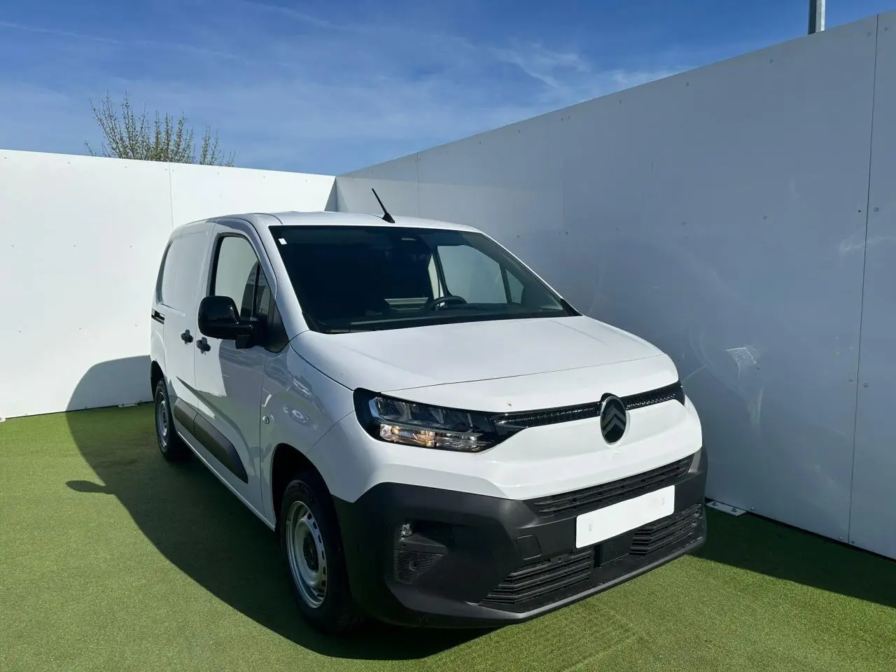 Profil droit du Citroën Berlingo III blanc Icy, fourgon utilitaire avec protections noires et jantes tôle grises.