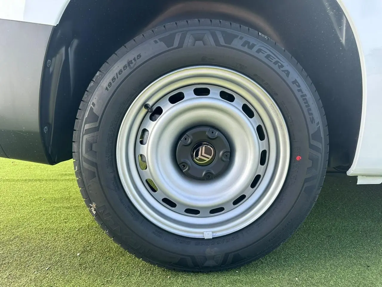 Gros plan sur la roue arrière droite en jante tôle grise du Citroën Berlingo blanc Icy 2026.