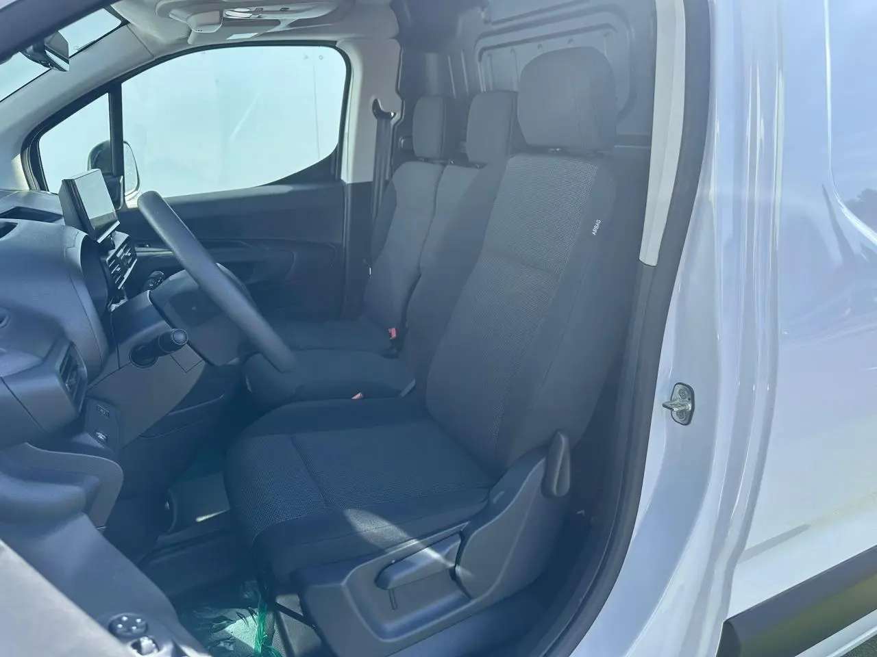 Vue 3/4 avant d’un utilitaire Citroën Berlingo blanc Icy avec pare-chocs noir mat et jantes tôle grises.