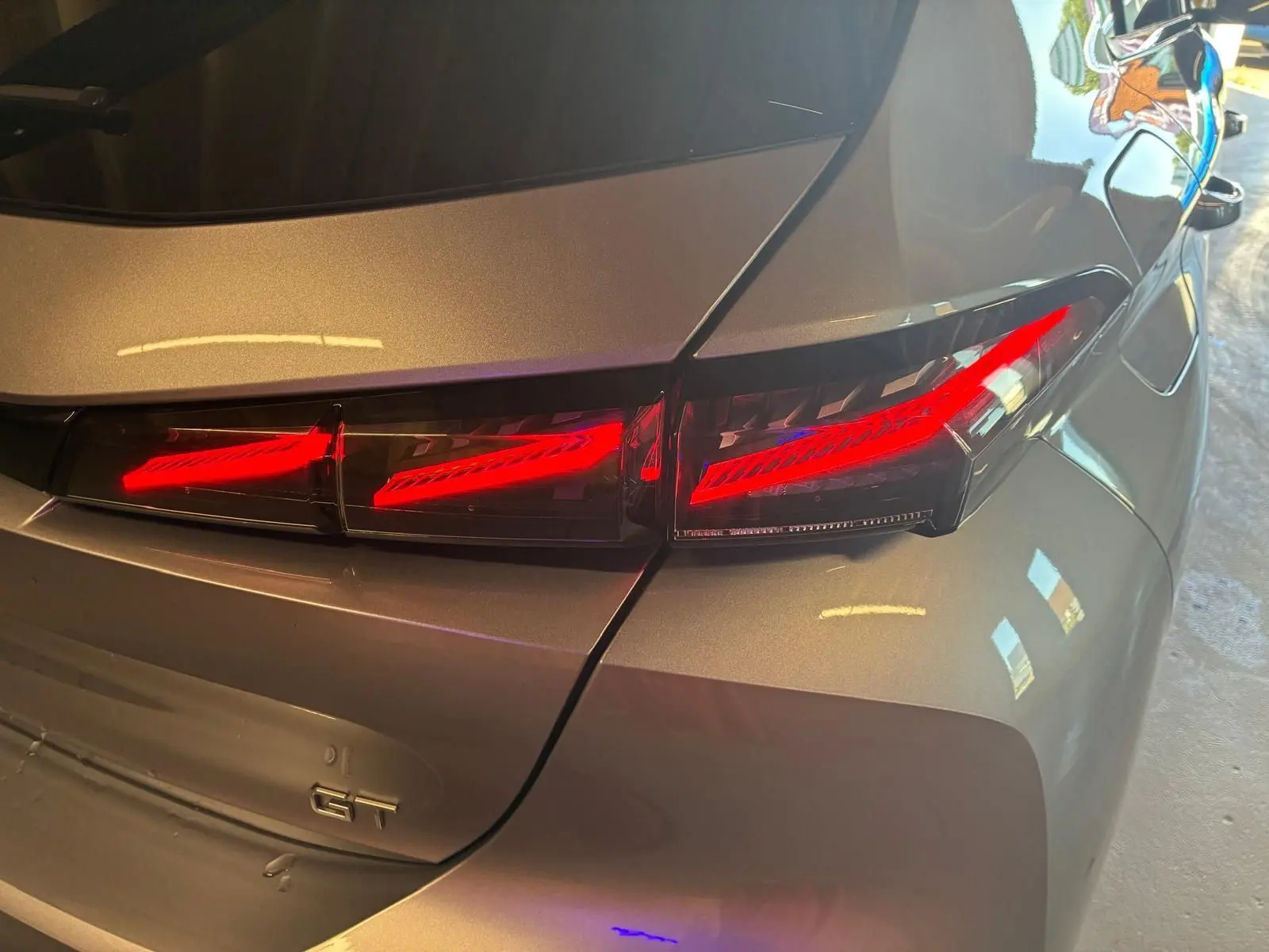 Feu arrière droit allumé sur Peugeot 308 gris 2025, version 1.2 HYBRID 136 E-DCS6 GT, vue rapprochée arrière.