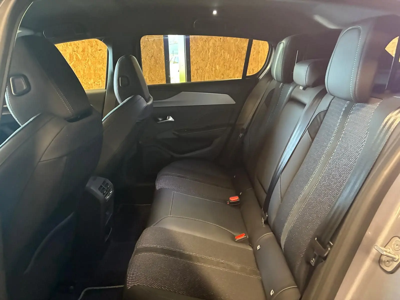 Vue intérieure arrière côté droit de la Peugeot 308 1.2 Hybrid 136 GT avec sièges noirs en tissu et cuir.