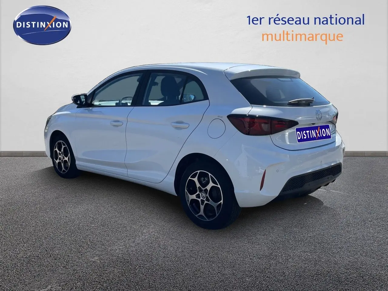 Vue 3/4 arrière droite d'une MG3 Dover White 2025, compacte hybride avec jantes alliage et feux arrière fumés.