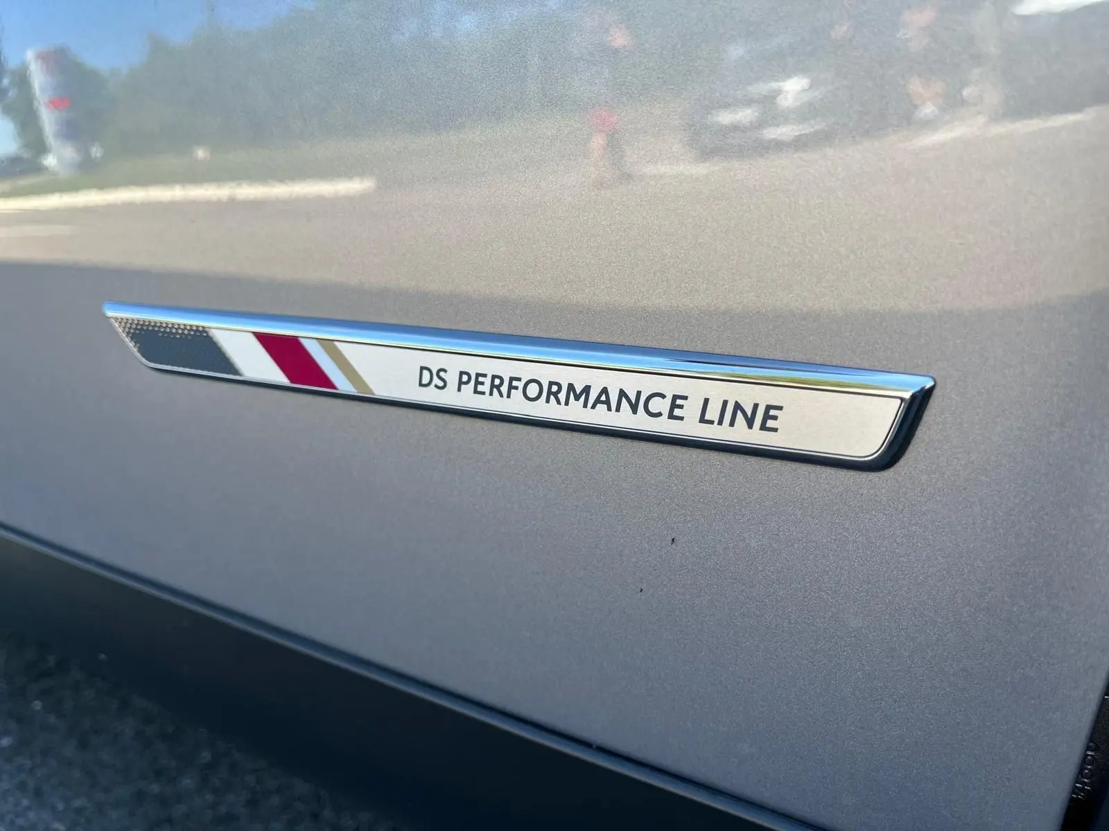 Gros plan sur le badge DS Performance Line sur la portière grise métallisée d'un DS3 Crossback 2022.