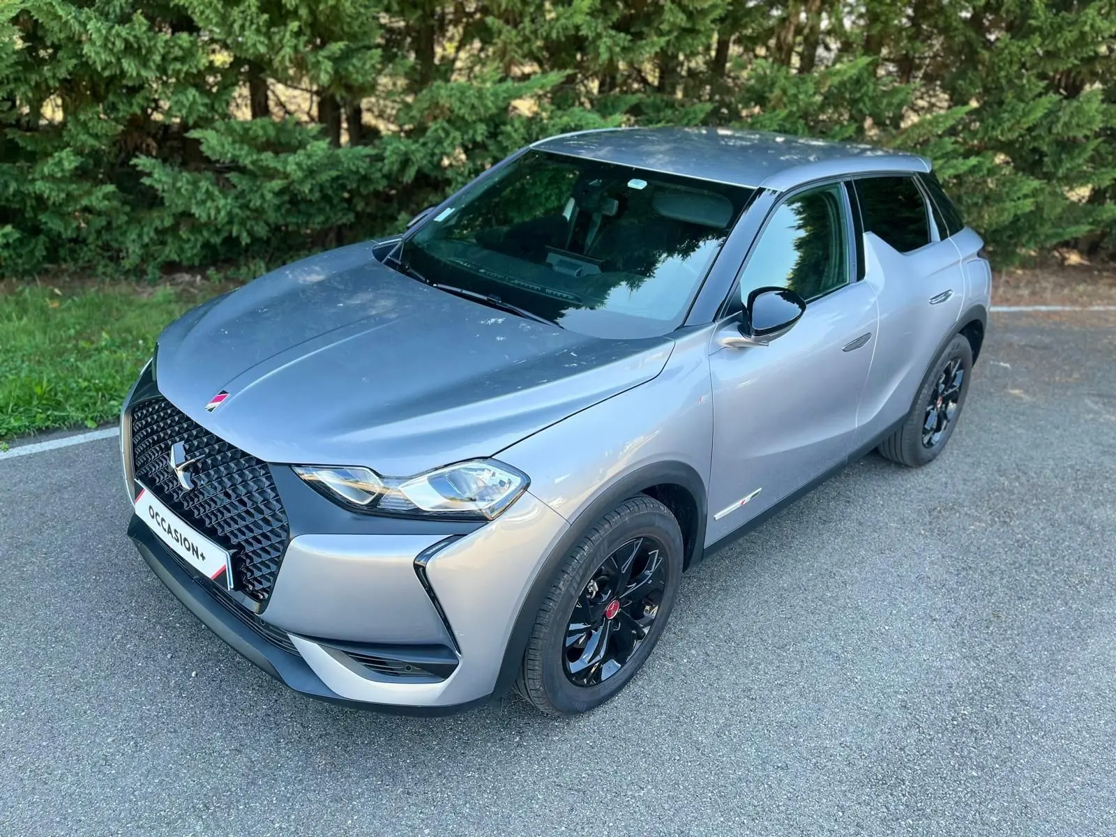 DS3 Crossback Performance Line grise vue 3/4 avant avec jantes noires et calandre distinctive noire.