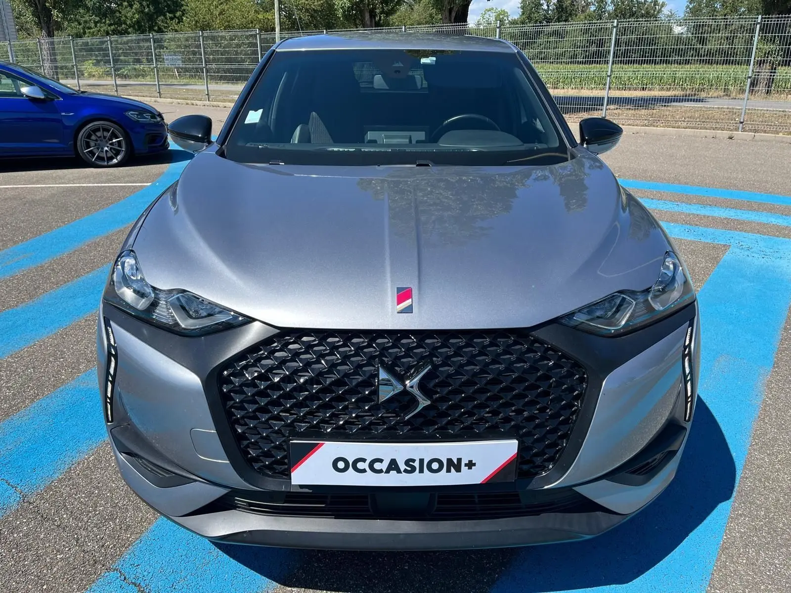 Vue avant d'un DS3 Crossback Performance Line gris métallisé avec calandre noire et badge DS distinctif.