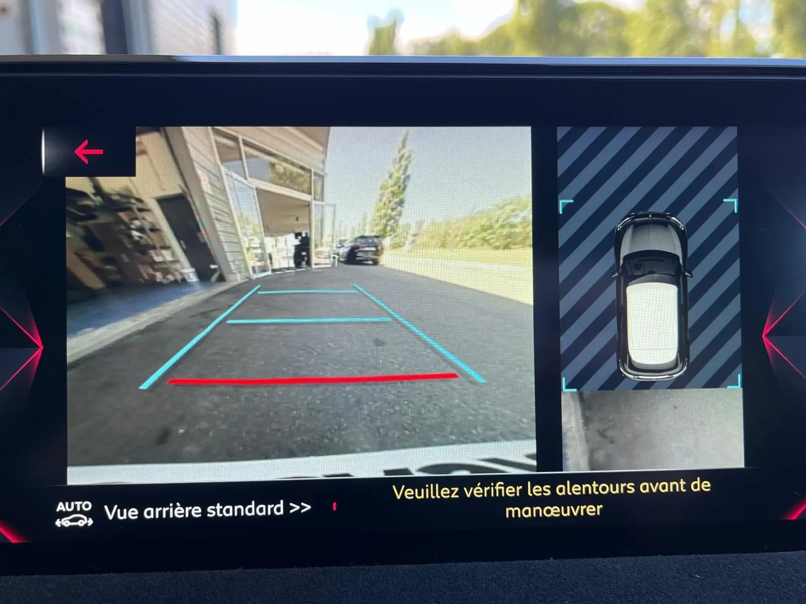 Vue caméra de recul et top-down du DS3 Crossback gris Performance Line, montrant l'aide au stationnement arrière.