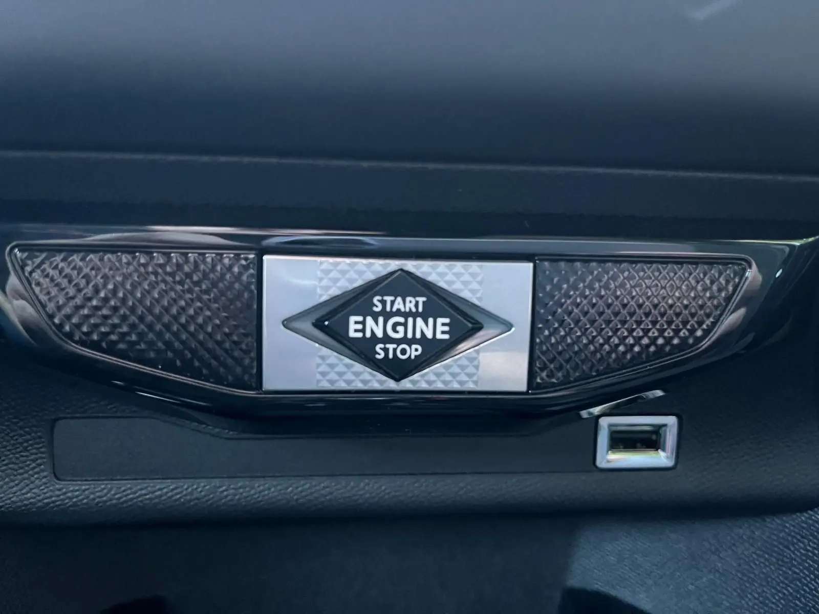 Bouton start/stop moteur avec inscription et prise USB visible sur la planche de bord du DS3 Crossback Performance Line gris.