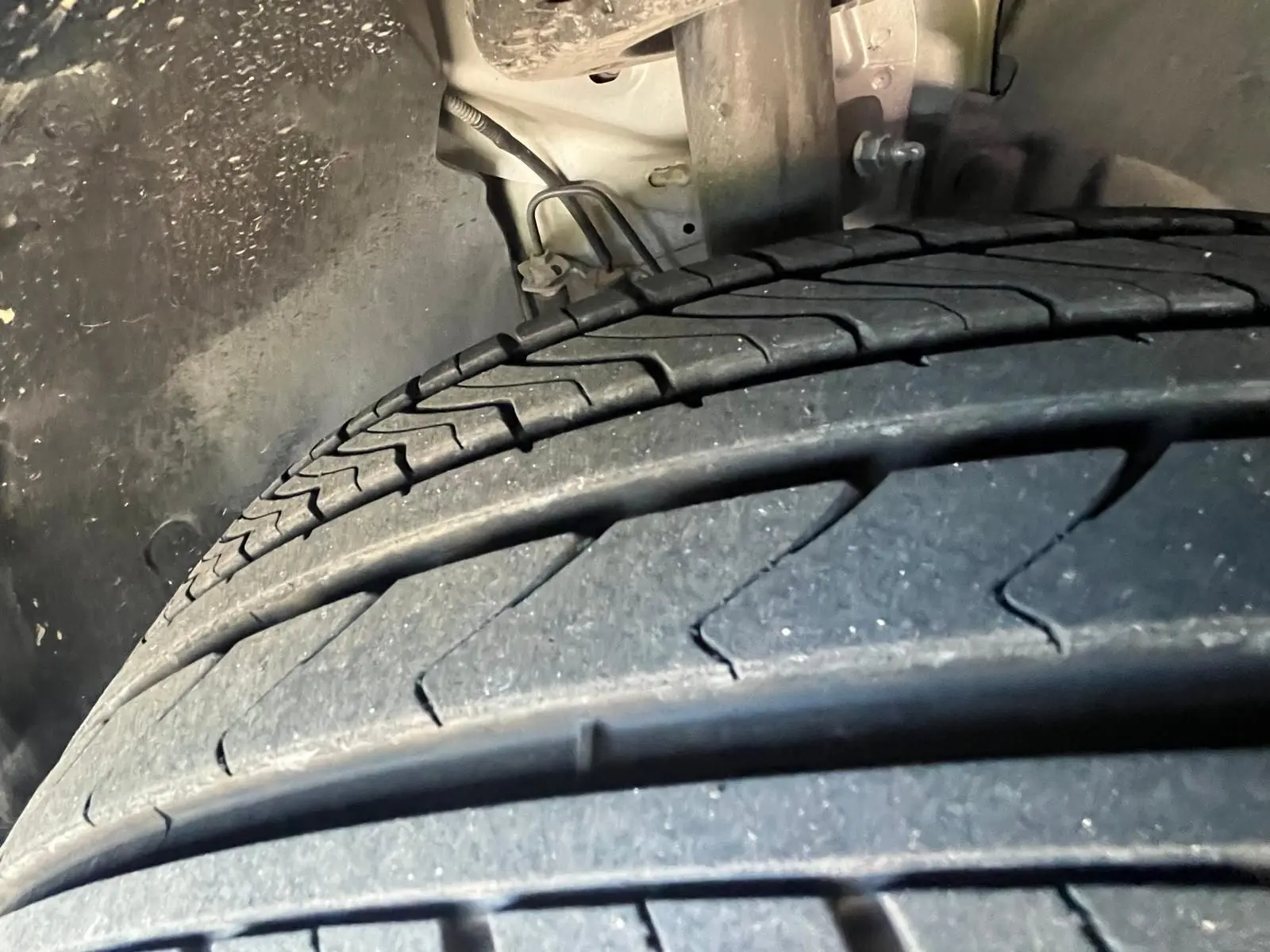 Gros plan sur le pneu arrière gauche du DS3 Crossback Performance Line gris, montrant la bande de roulement et l'intérieur de l'aile.