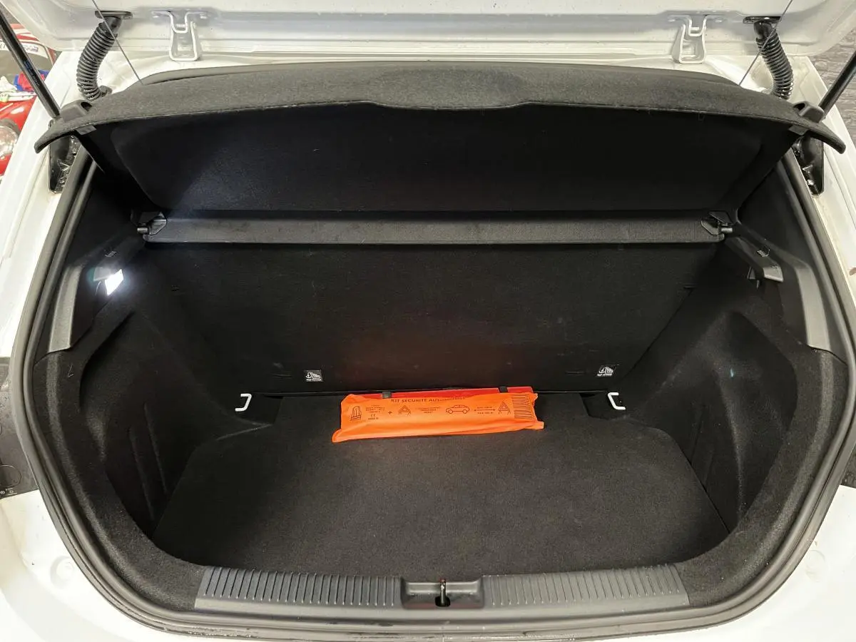 Coffre ouvert d'une MG3 blanche vue de l'arrière, avec un triangle de sécurité orange posé à l'intérieur.