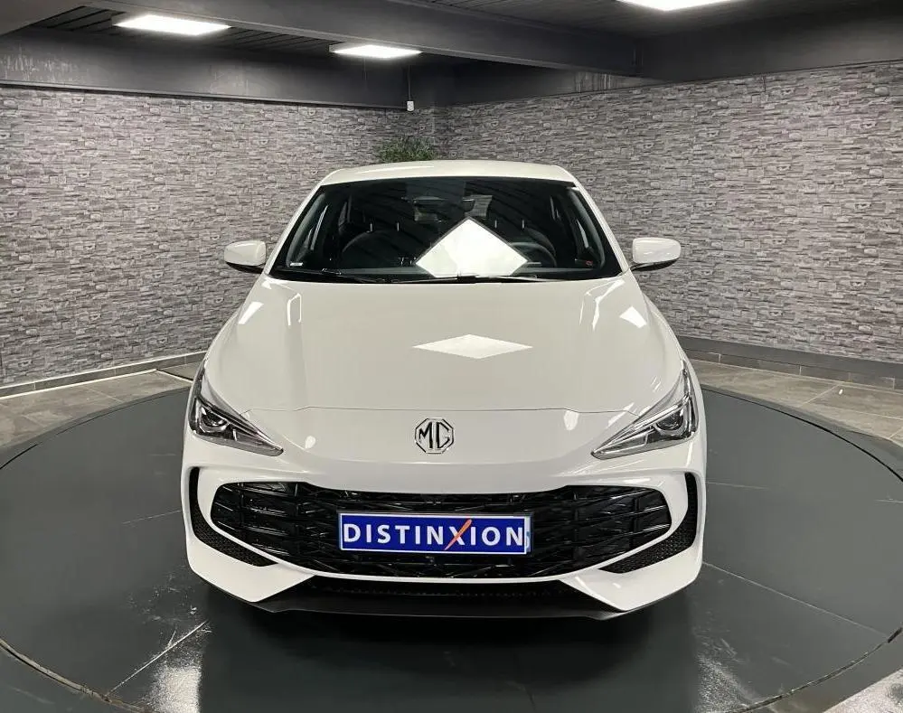 Vue frontale d'une MG3 blanche 2024 avec calandre noire et logo MG au centre dans un showroom.