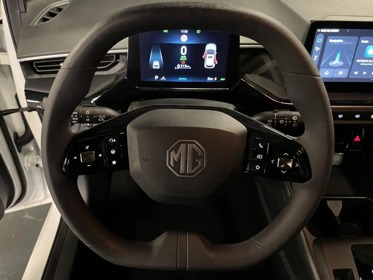 Vue rapprochée du volant noir de la MG3 1.5 Hybrid+ 195 Comfort 2024 avec tableau de bord numérique allumé.