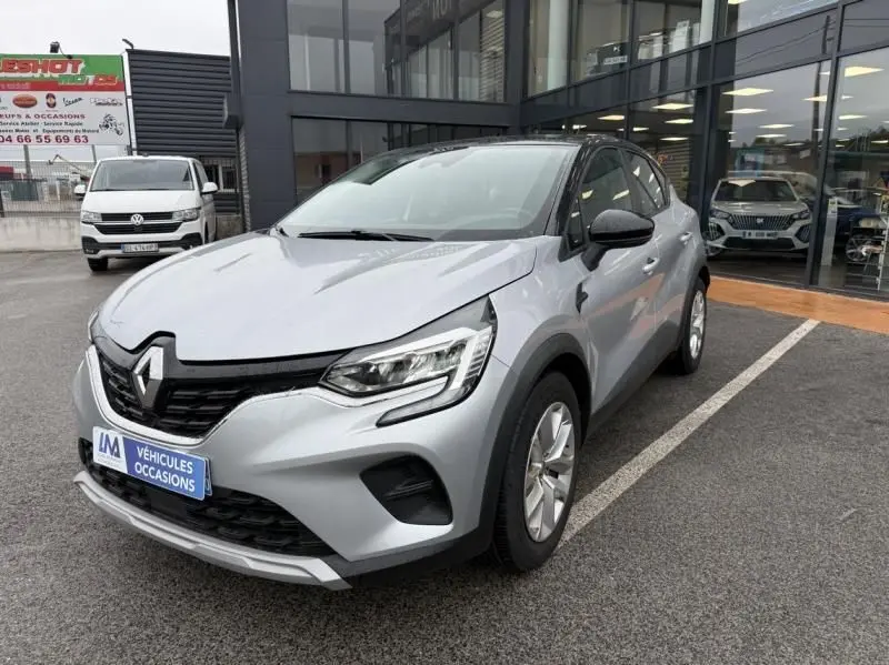 Renault Captur E-Tech 145 Zen gris métal vu en 3/4 avant droit, avec calandre noire et phares LED distinctifs.