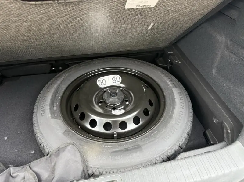 Roue de secours noire dans le coffre d'un Renault Captur E-Tech 145 Zen gris métal 2022, essence hybride.