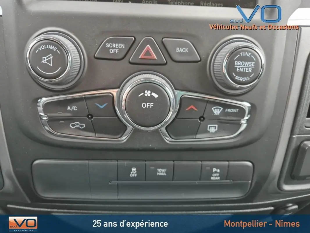 Vue rapprochée du tableau de bord noir du Dodge RAM Crew SLT Classic 2022, montrant les commandes climatisation et audio.