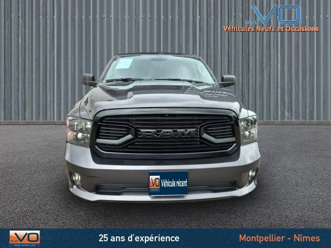Vue frontale d'un Dodge RAM Crew SLT Classic Black Package gris foncé 2022 avec calandre noire distinctive.