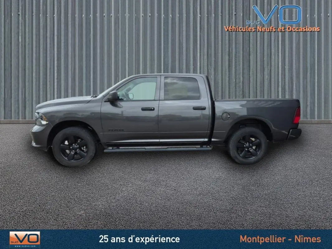 Vue latérale gauche d'un Dodge RAM Crew SLT Classic Black Package gris foncé avec jantes noires, 2022.