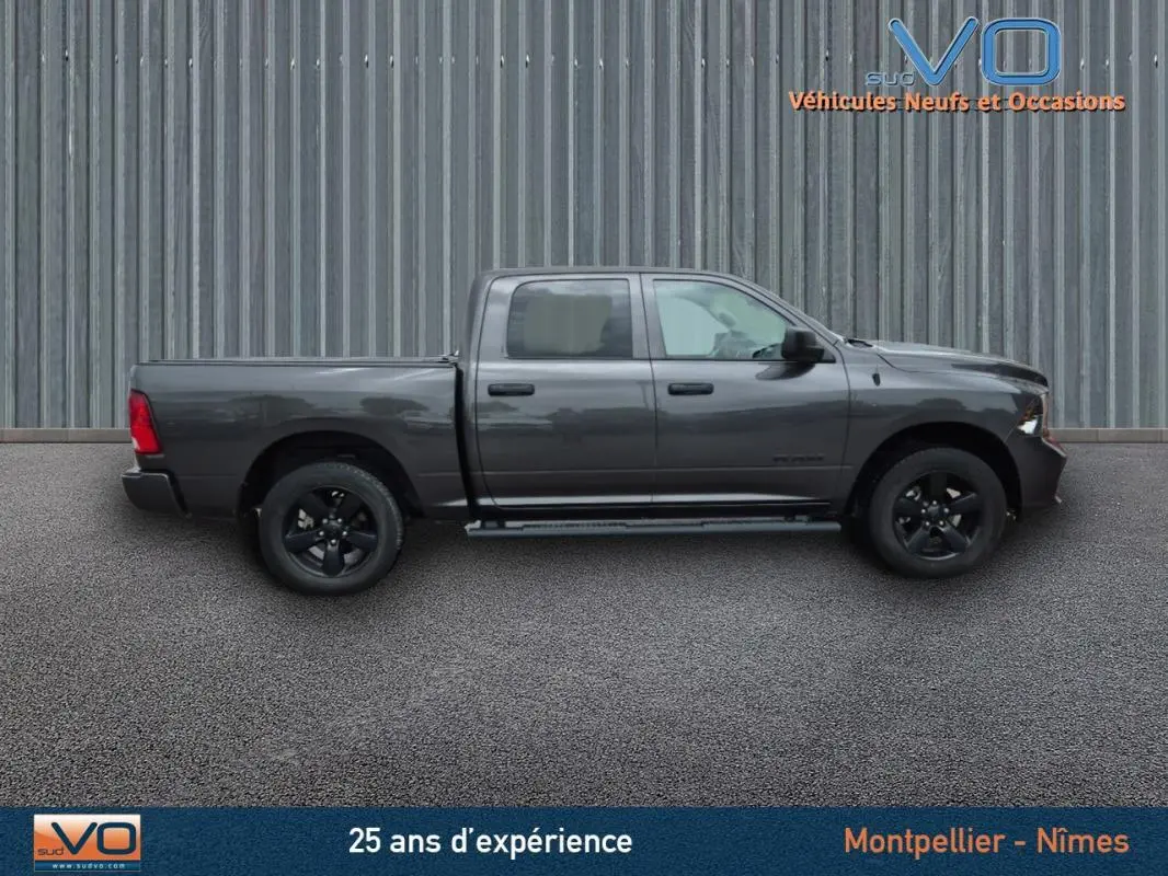 Vue latérale droite d'un Dodge RAM Crew SLT Classic Black Package gris foncé 2022 avec jantes noires et cabine double.
