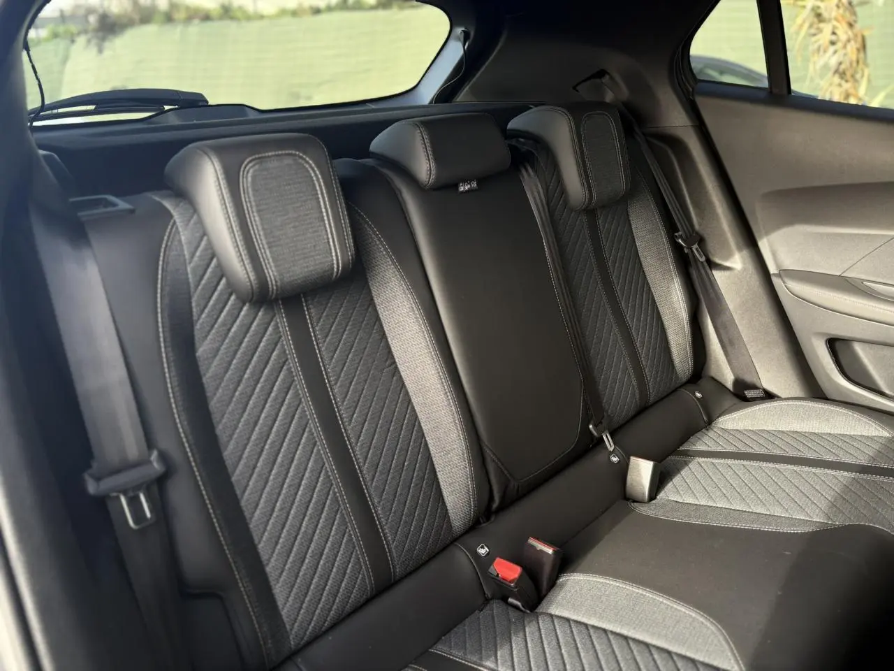 Vue intérieure de la banquette arrière en tissu gris et cuir noir du Peugeot 2008 Hybrid 145 e-DSC6 Allure 2025.