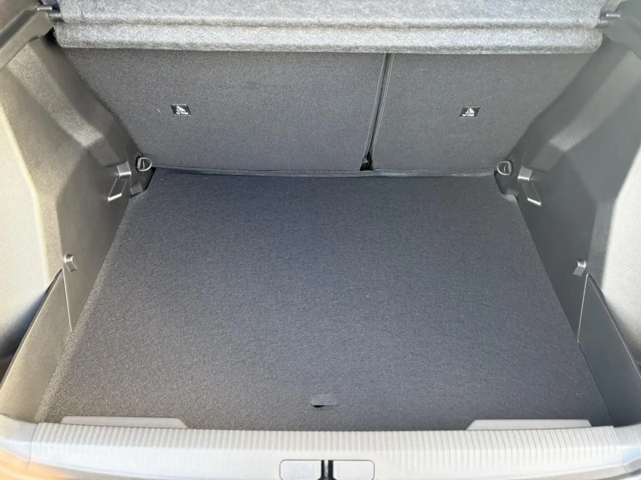 Coffre ouvert de Peugeot 2008 Hybrid 145 e-DSC6 Allure gris Selenium, montrant un espace de rangement vide et propre.