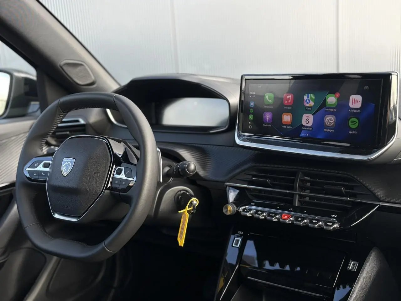 Vue intérieure du tableau de bord et volant cuir noir du Peugeot 2008 Hybrid 145 e-DSC6 Allure avec écran tactile 10 pouces.