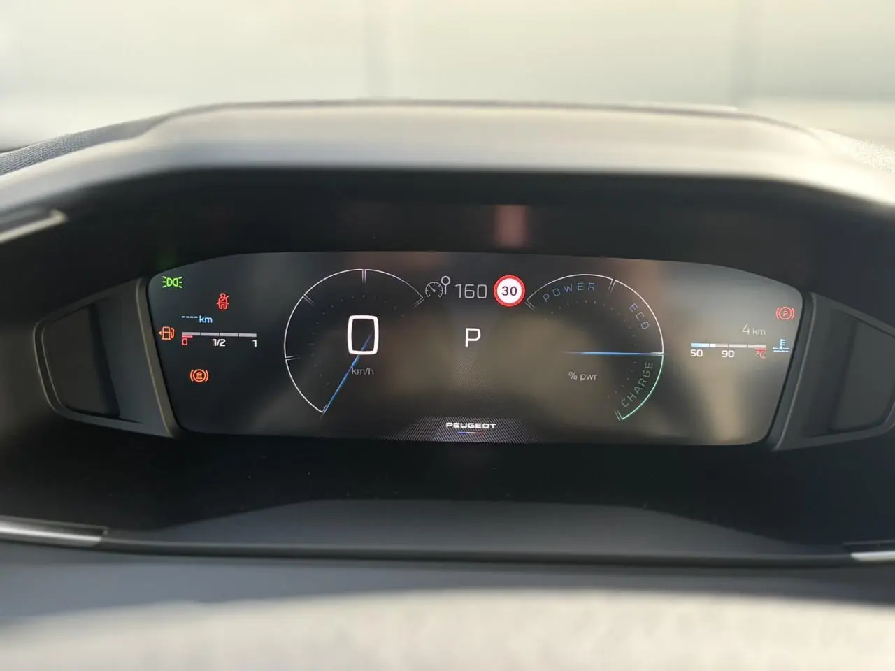 Vue rapprochée du combiné numérique Peugeot 2008 Hybrid 145 e-DSC6 Allure affichant vitesse, mode parking et indicateurs divers.