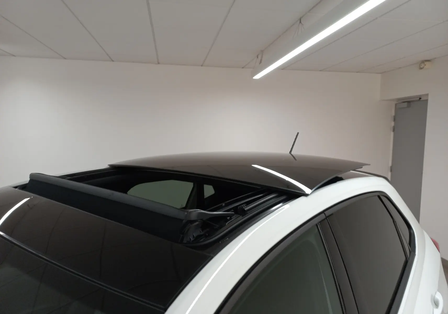 Vue rapprochée du toit ouvrant noir ouvert sur une Volkswagen Polo 2.0 TSI GTI blanc pur, angle arrière droit.