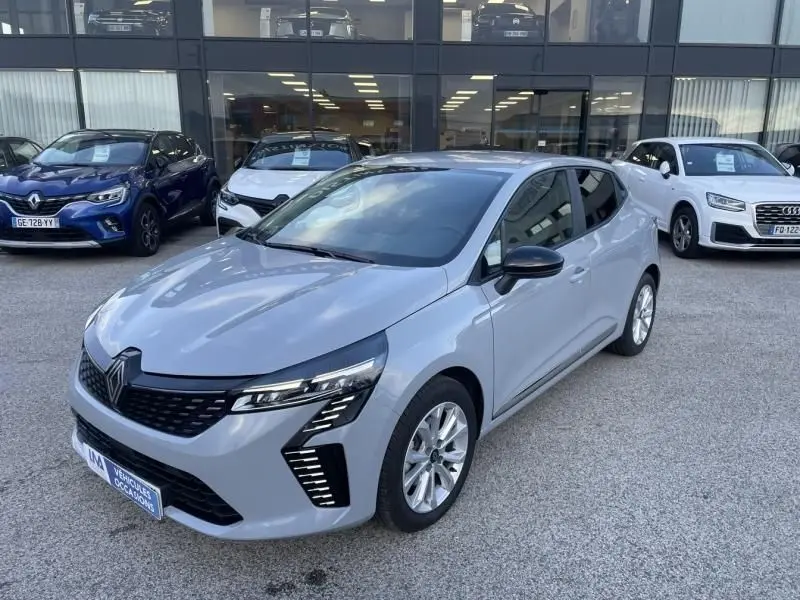 Renault Clio V DCI 100 Evolution gris métal vue 3/4 avant droit, avec feux LED et jantes alliage visibles.