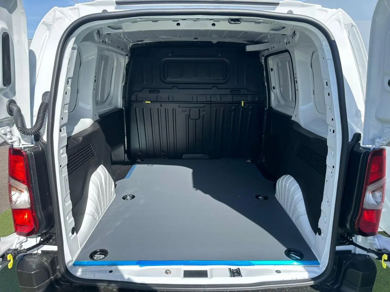 Détail de l’intérieur côté passager du Citroën Berlingo blanc, montrant la planche de bord et la grille d’aération.