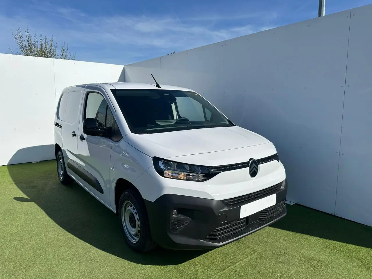 Vue de profil côté gauche d’un Citroën Berlingo III Van blanc Icy avec jantes tôles grises et poignées noires.