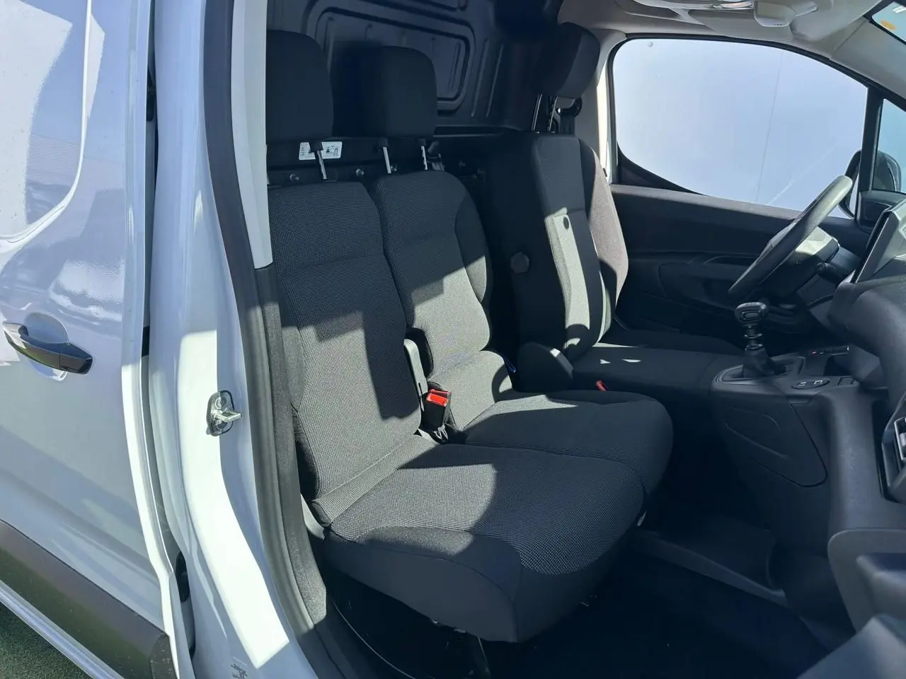 Vue intérieure côté gauche du Citroën Berlingo blanc Icy, montrant la banquette passager 2 places et la cabine Extenso.