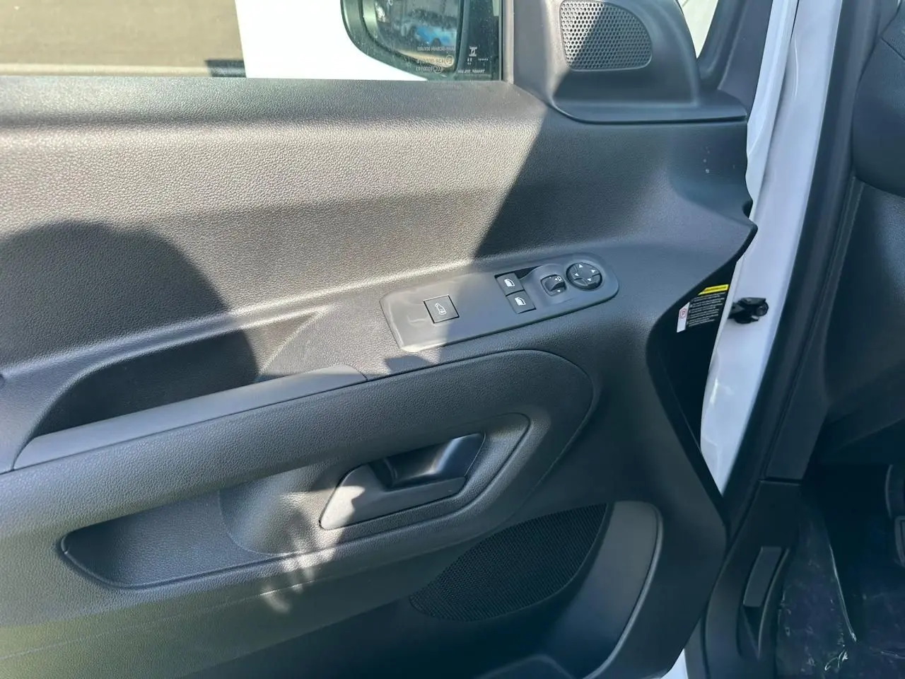 Vue rapprochée de la portière avant gauche noire du Citroën Berlingo blanc Icy avec commandes de vitres et rétroviseurs.