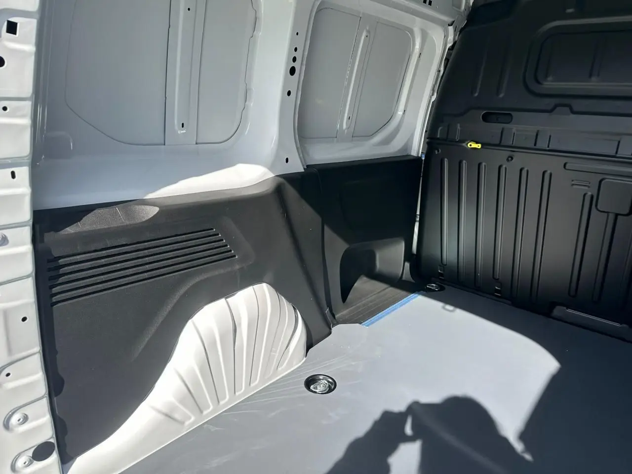 Vue intérieure arrière droite du coffre blanc Icy du Citroën Berlingo III Van Taille M avec plancher et anneaux d’arrimage.