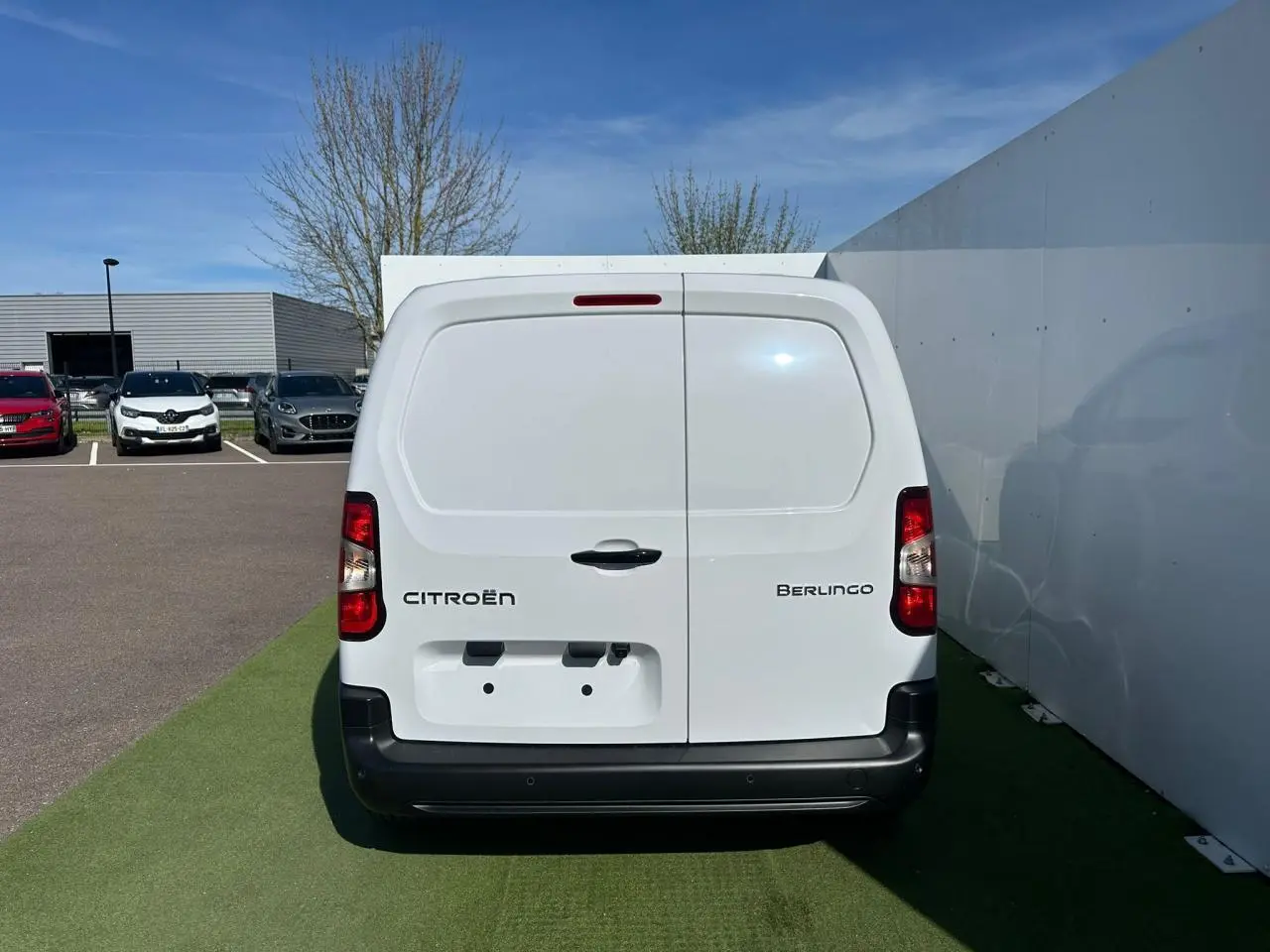 Vue 3/4 arrière droite du Citroën Berlingo blanc Icy version utilitaire avec portes arrière tôlées fermées.