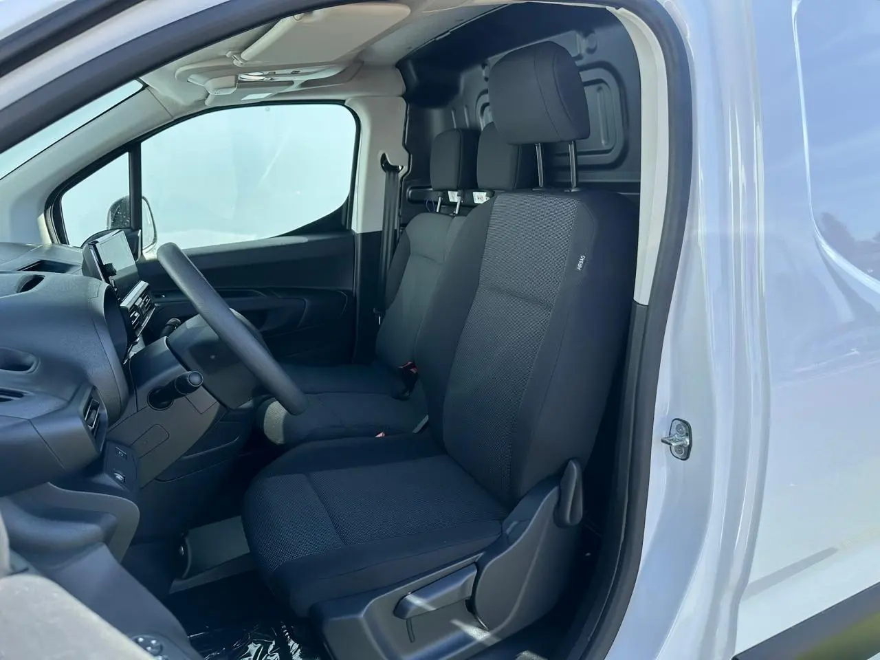 Gros plan sur la caméra de recul noire intégrée à la porte latérale droite du Citroën Berlingo blanc Icy.