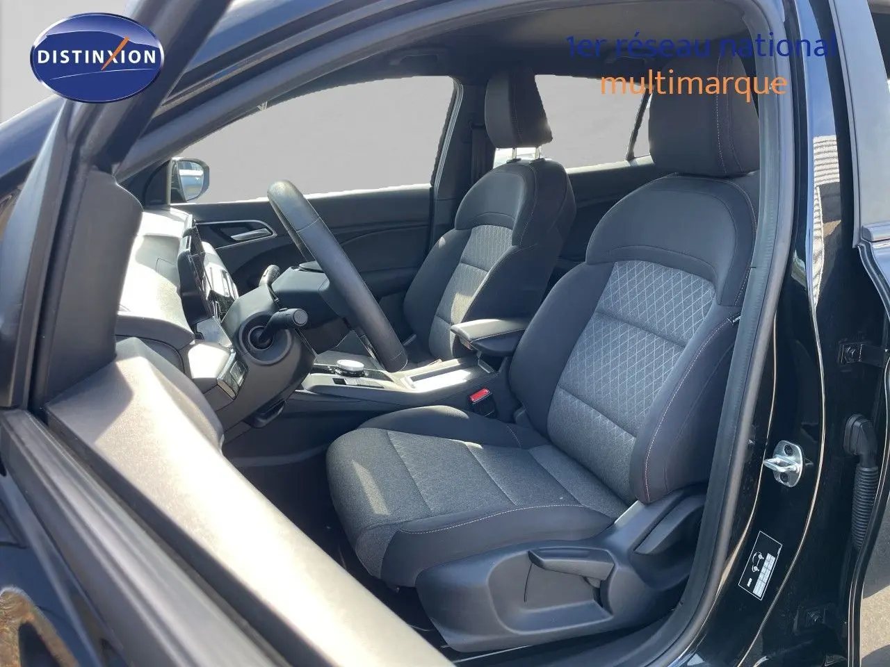 Vue intérieure côté conducteur de la MG3 1.5L Hybrid+ 2024 en Pebble Black Metal, sièges tissu gris noir avec motifs.
