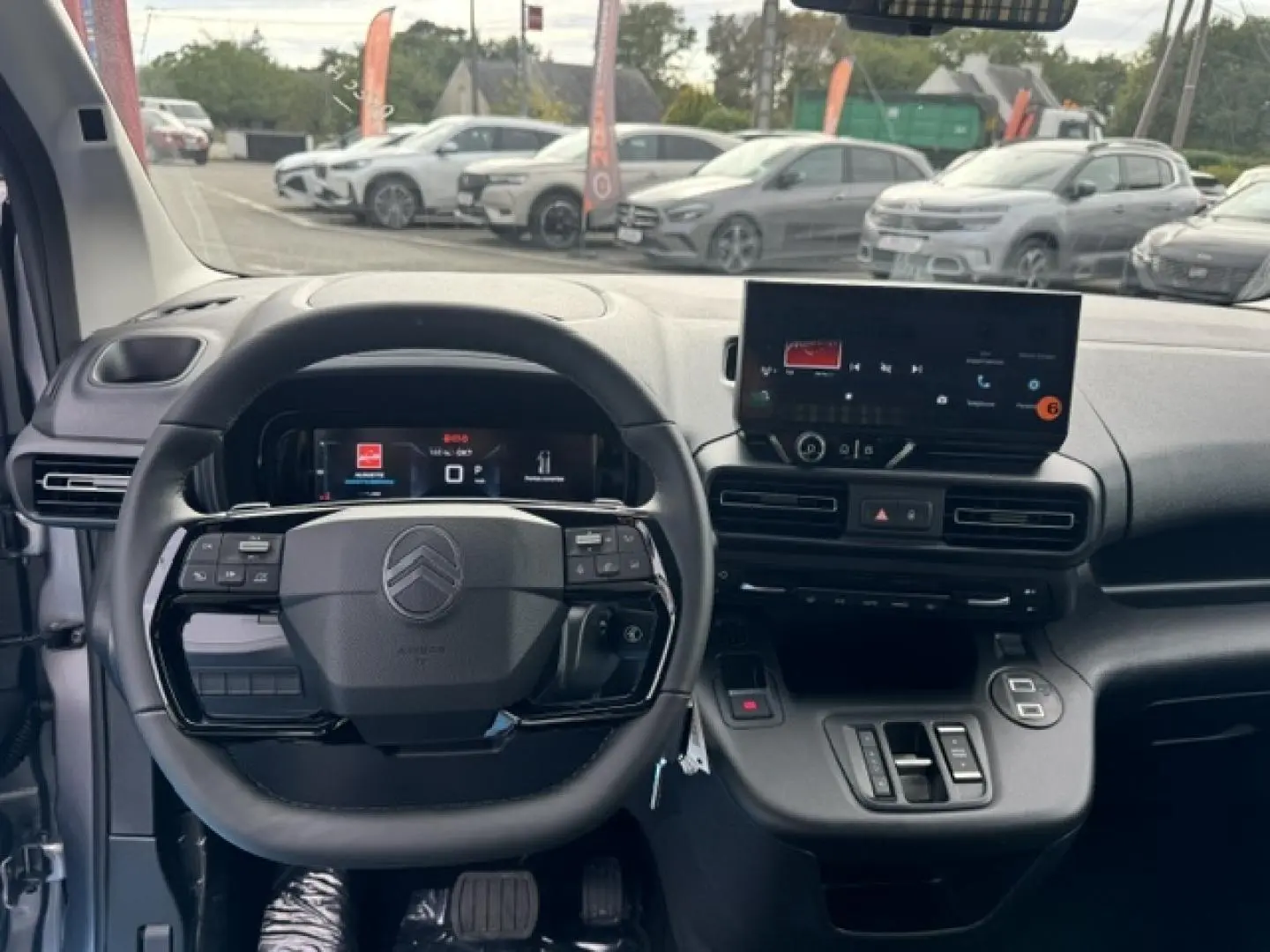 Vue intérieure frontale du tableau de bord et volant cuir noir du Citroën Berlingo gris acier 2026 avec écran tactile.