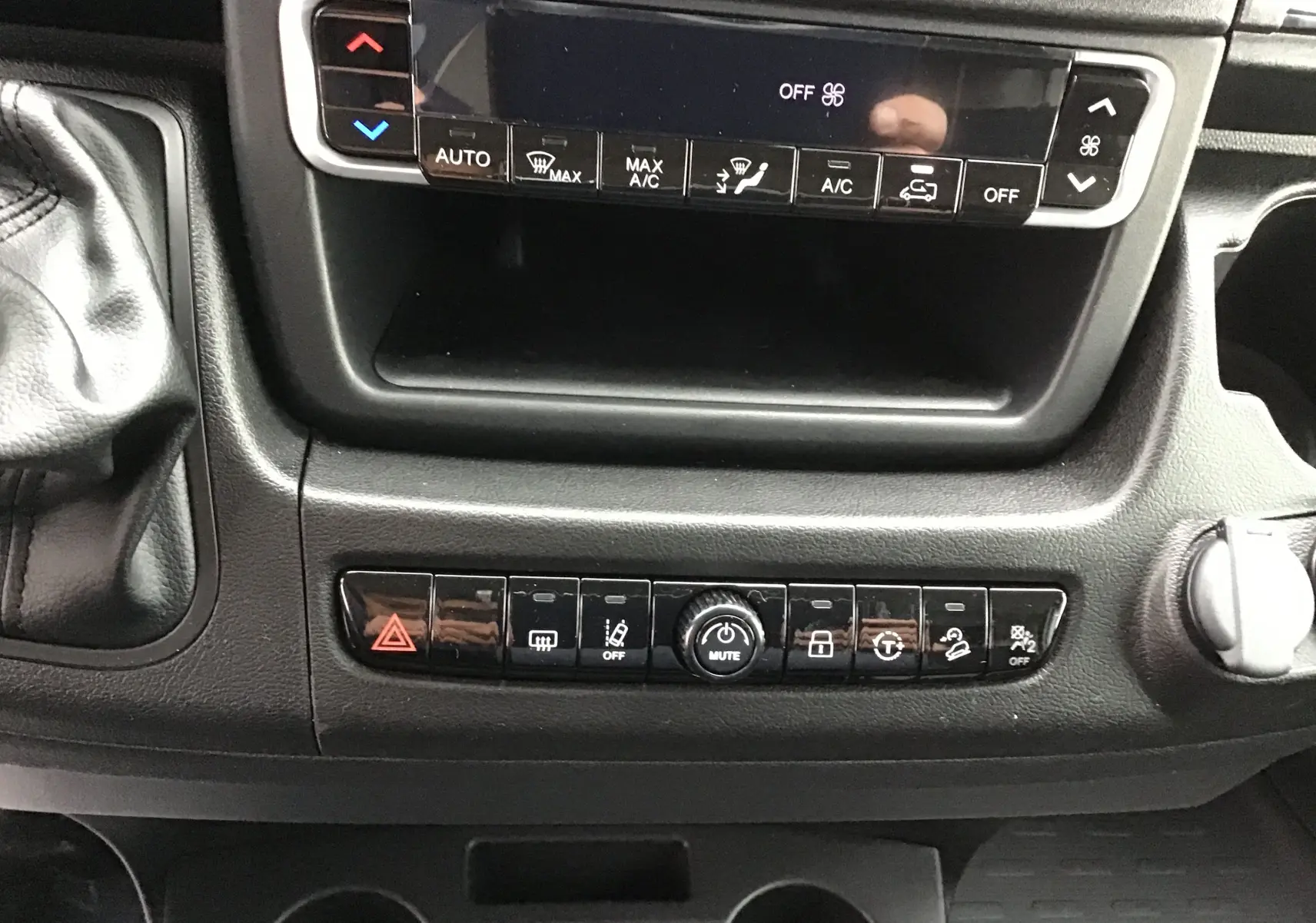 Vue rapprochée de la console centrale du Peugeot Boxer Fourgon blanc, montrant les commandes climatisation et boutons multifonctions.