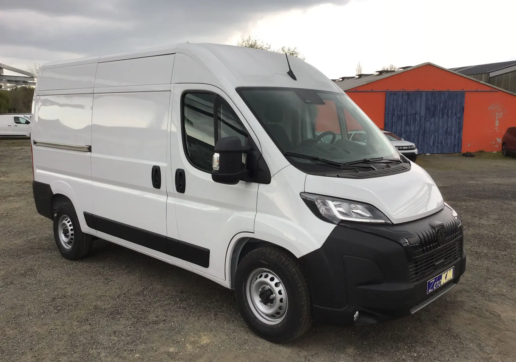 Vue 3/4 avant droit d’un Peugeot Boxer Fourgon blanc 2025 avec pare-chocs noir et carrosserie lisse.